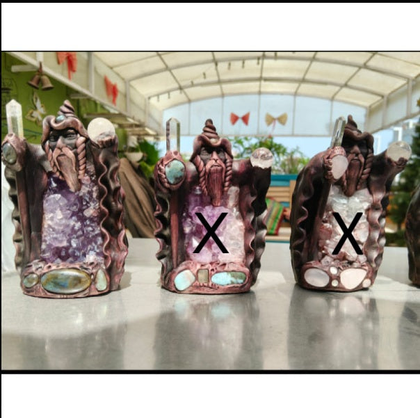 Three decorative figurines with crystal-like designs on a reflective surface.