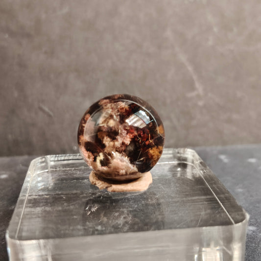 garden quartz with rutile well polished in sphere on transparent base