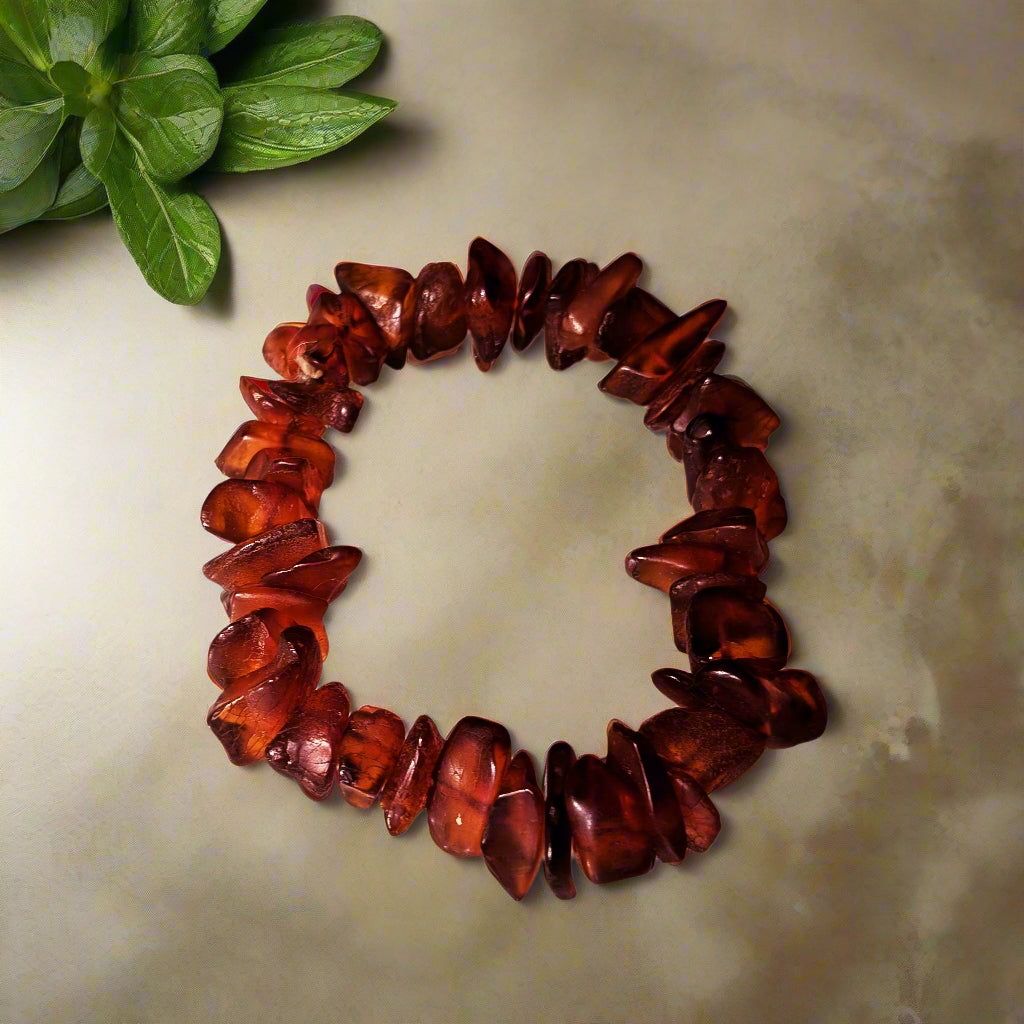 A bracelet made of natural amber chips, displayed on a neutral background.