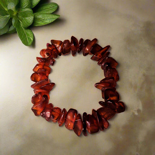 A bracelet made of natural amber chips, displayed on a neutral background.