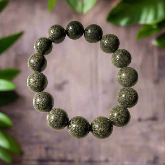 A green garden quartz bracelet with 16mm beads, displayed against a wooden background with green leaves.