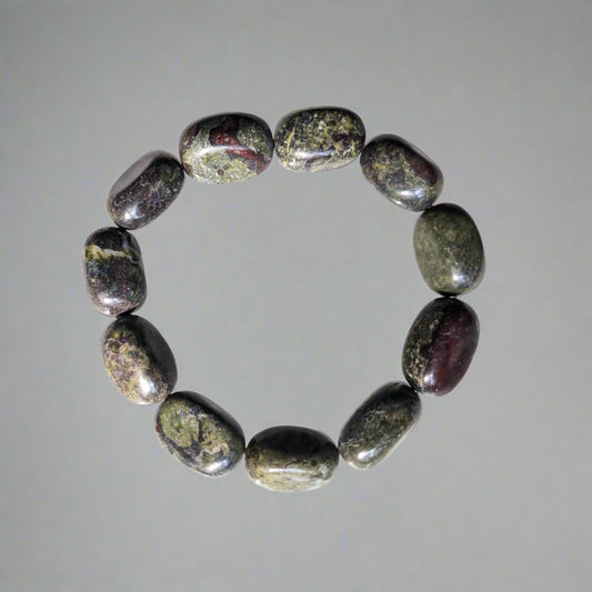 A Dragon Blood Tumble Bracelet with polished tumble stones arranged in a circle, displaying deep green and red hues.