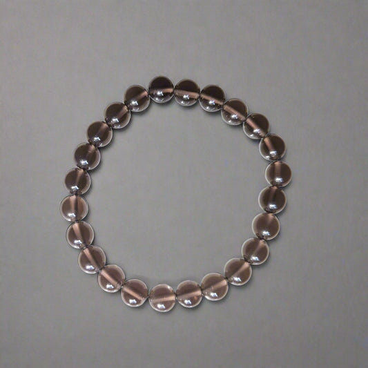 A silver bracelet featuring round 8mm beads laid out on a flat surface.