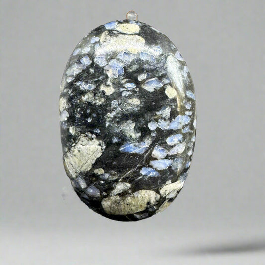 Que Sera palmstone with a mix of blue, gray, and brown tones, polished smooth to enhance its unique swirling patterns and calming energy