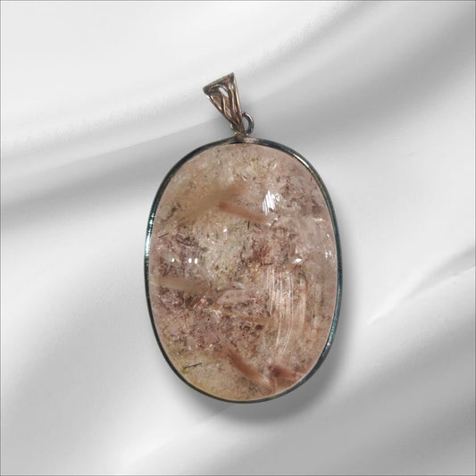 An oval-shaped pink rutile gemstone pendant set in a silver mounting, with a loop for a chain attachment at the top.