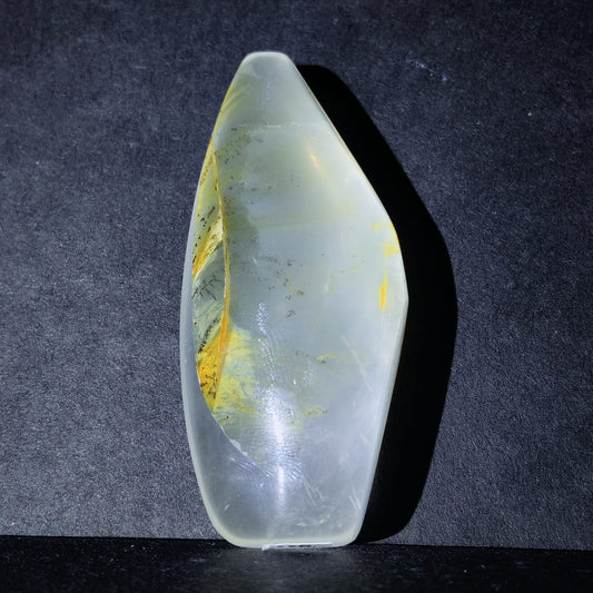 Translucent stone with yellow inclusions on a dark background