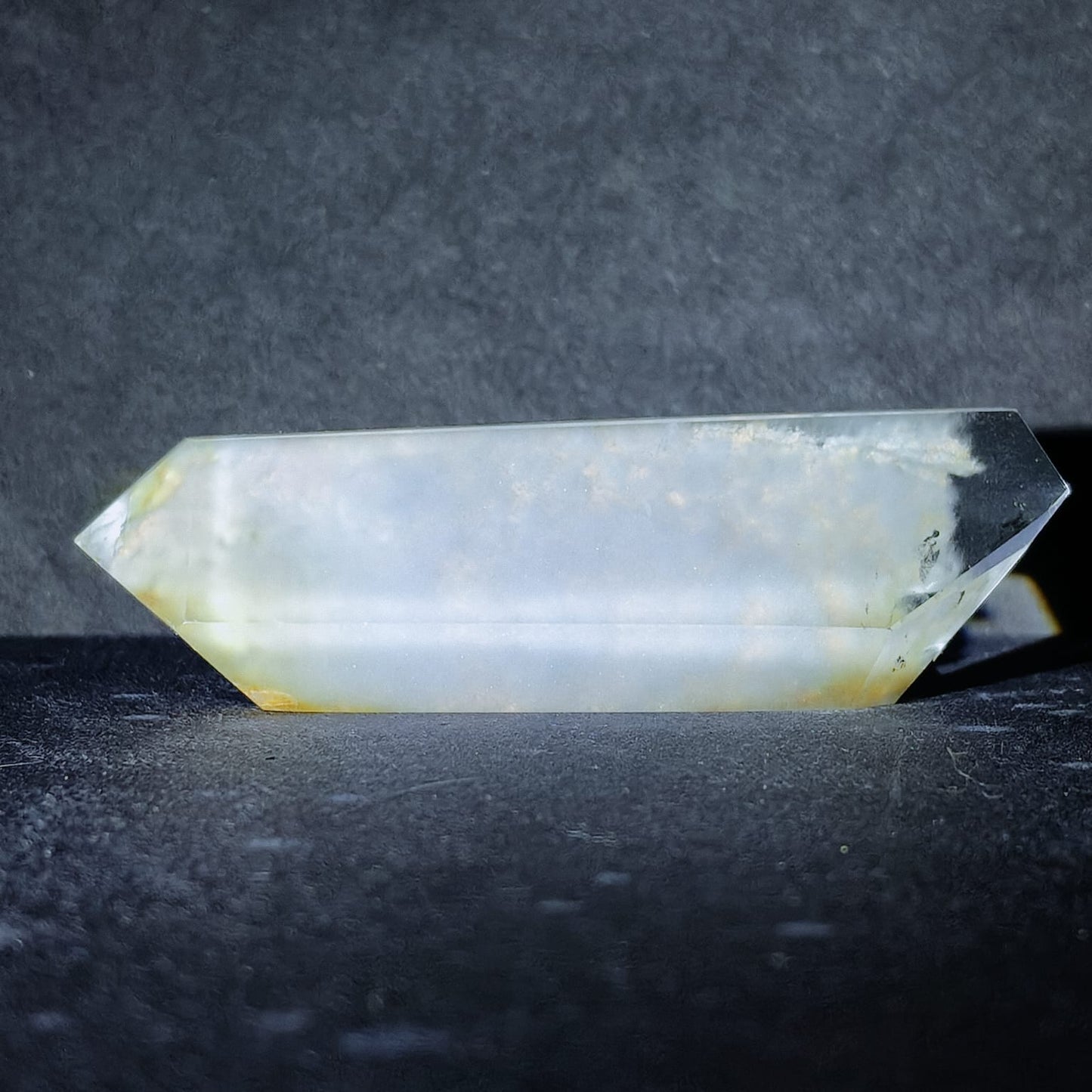 Crystal prism on a dark textured surface