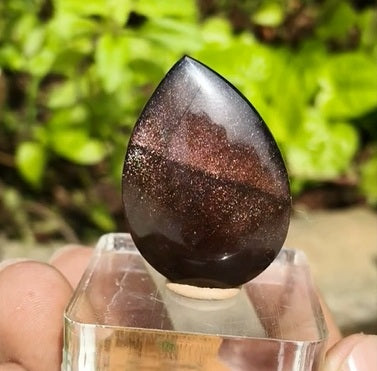 a tear-shaped crystal with sparkling red and golden streaks, symbolizing energy, passion, and confidence