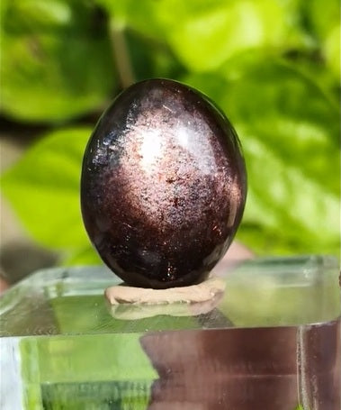 Bloodshot Sunstone Freeform – a polished gemstone with fiery red and golden inclusions, radiating warm shimmer and vitality.