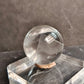 Clear crystal ball on a dark stone surface